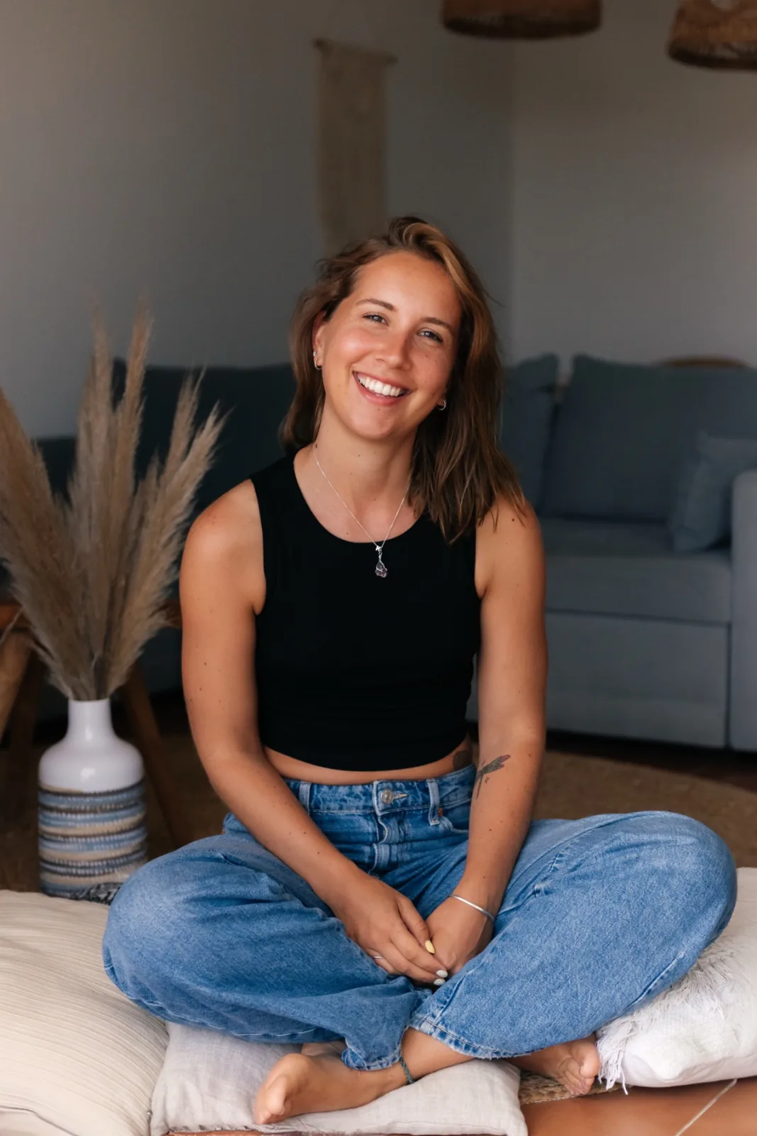 Kristel zit ontspannen in kleermakerszit op vloerkussens